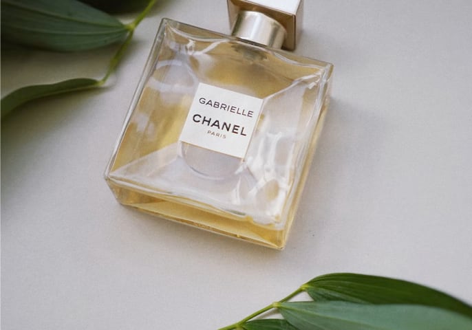 image of a chanel perfurme bottle surrounded by leaves